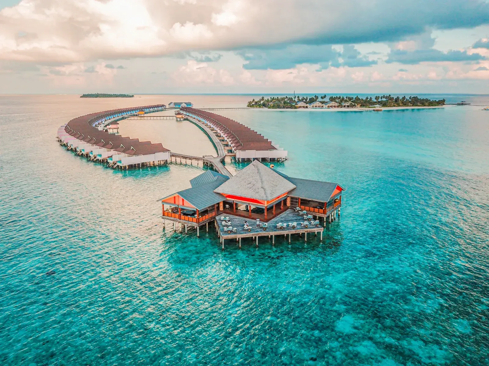 Lagune turquoise et bungalows sur pilotis — ambiance resort haut de gamme, image d’accueil pour l’assurance tourisme professionnel et hôtellerie RMA Tanger